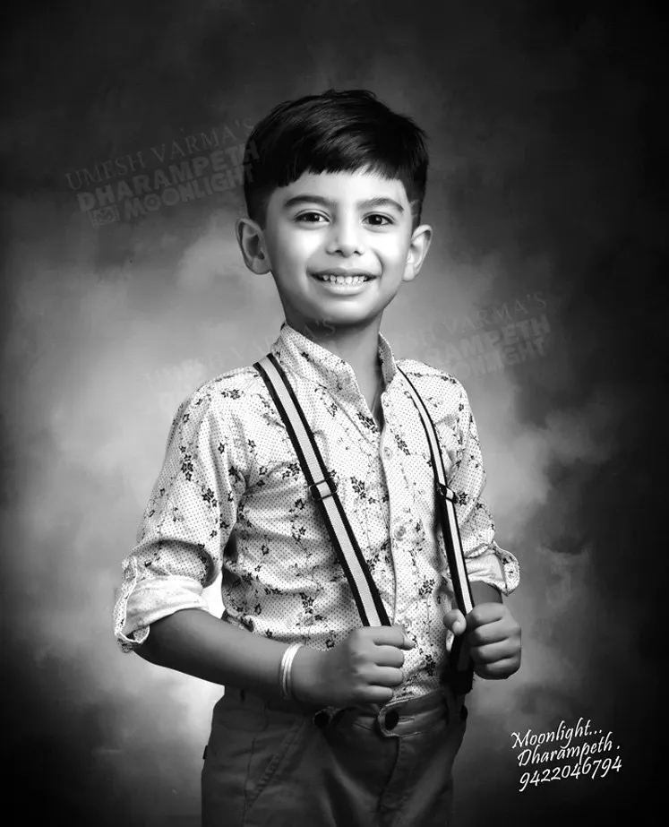 Black and white portrait of a young boy in suspenders