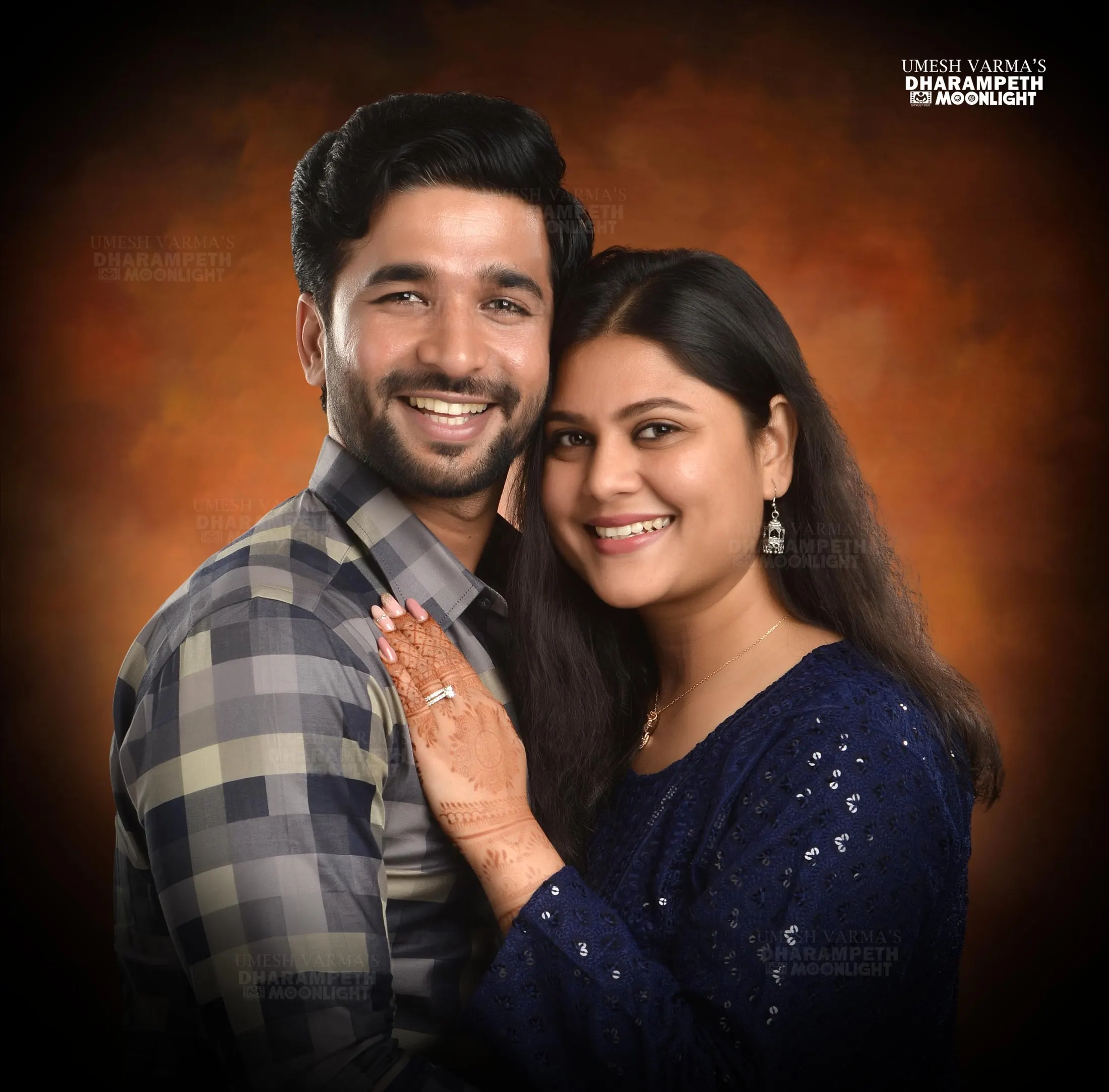 Smiling couple posed close together against a warm backdrop