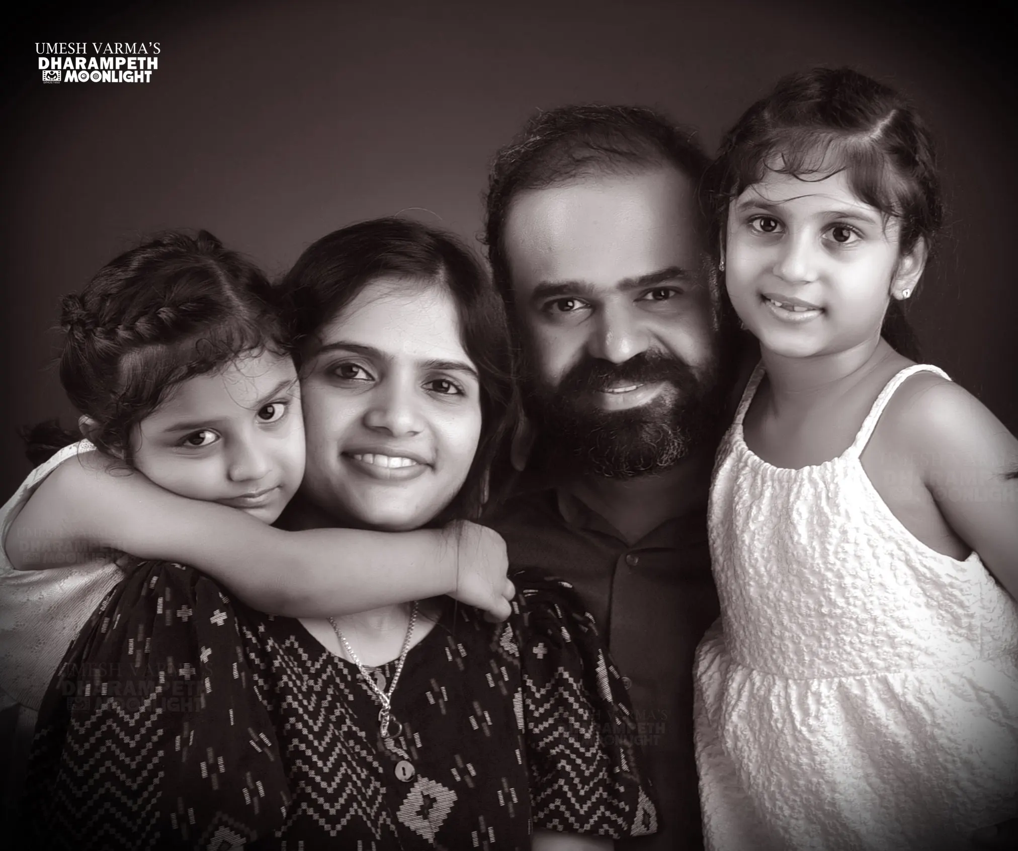 Black and white portrait of a laughing family of four