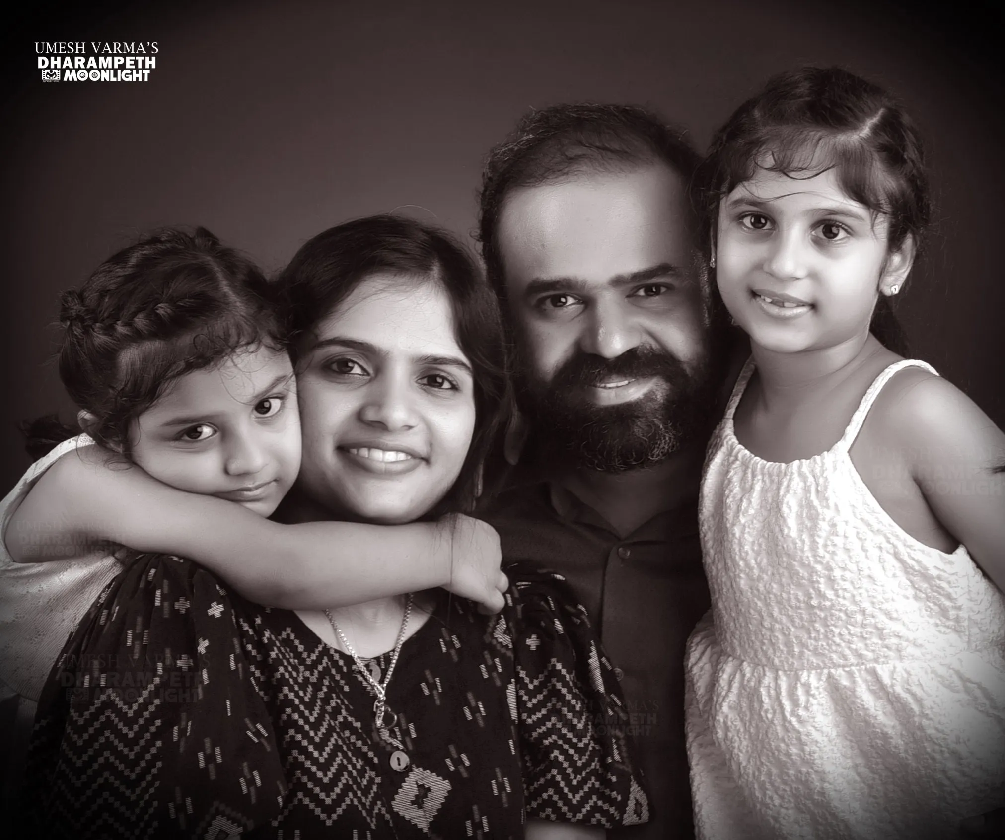Black and white portrait of a laughing family of four