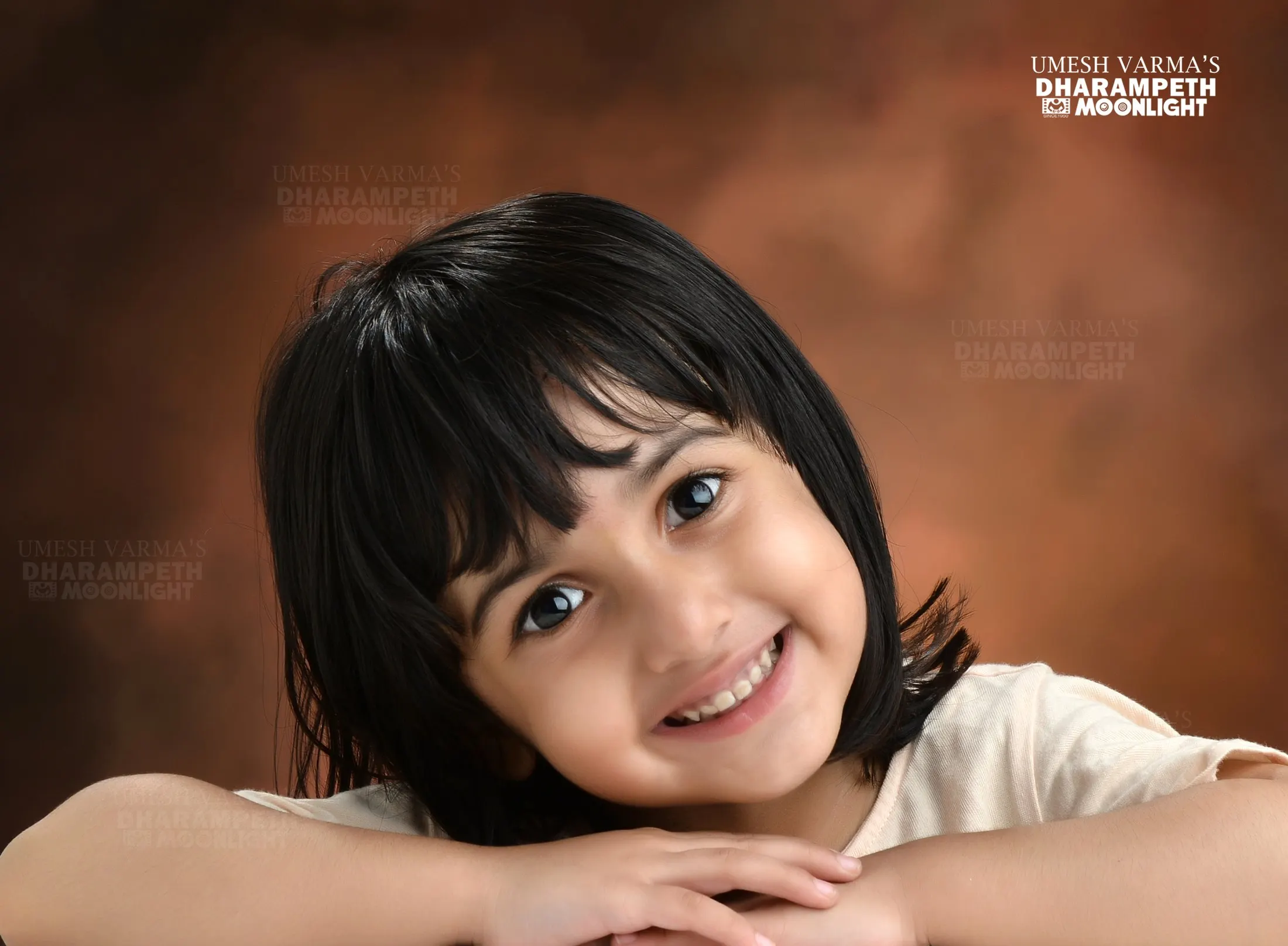 Smiling young girl resting her chin on her hands