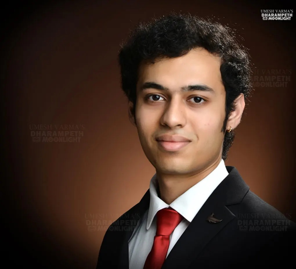 Headshot of a young man in a suit and red tie