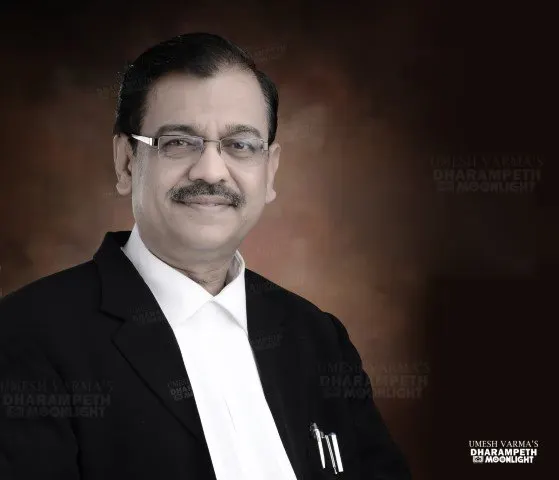 Formal portrait of a senior advocate in a black coat
