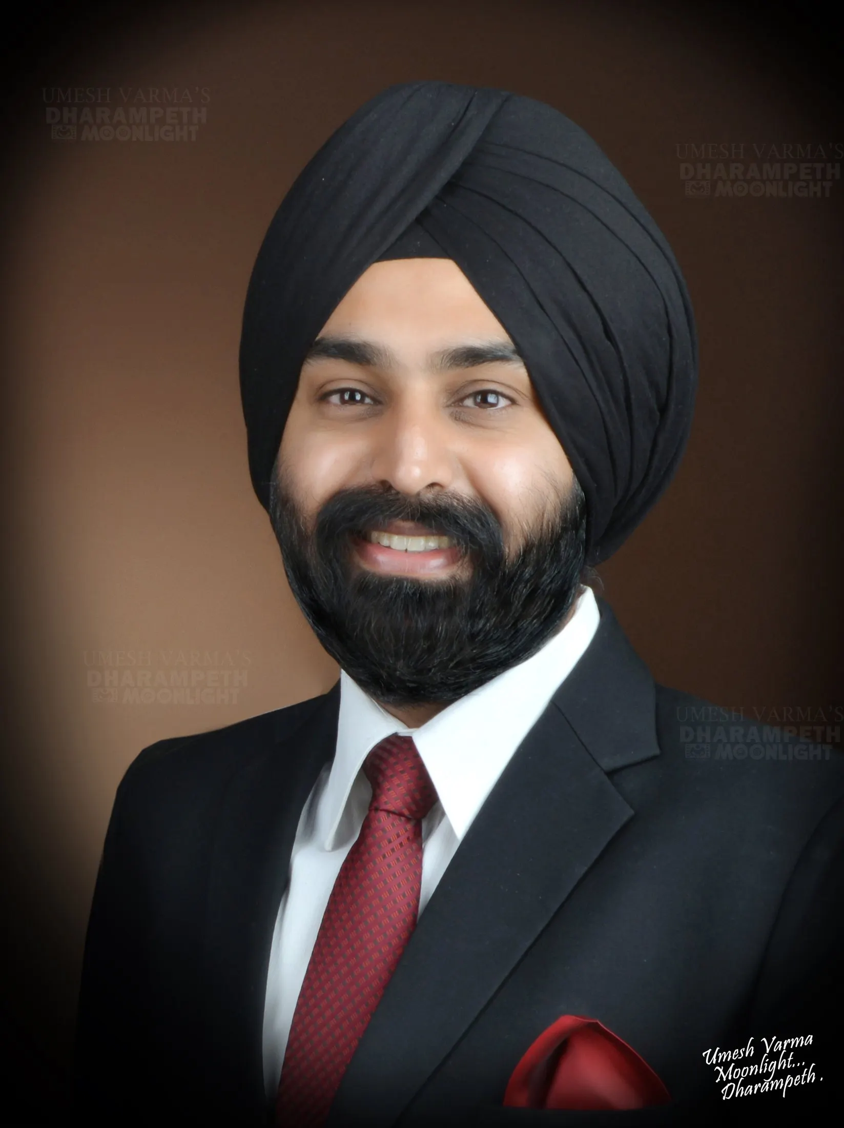Portrait of a Sikh gentleman in a black suit and turban