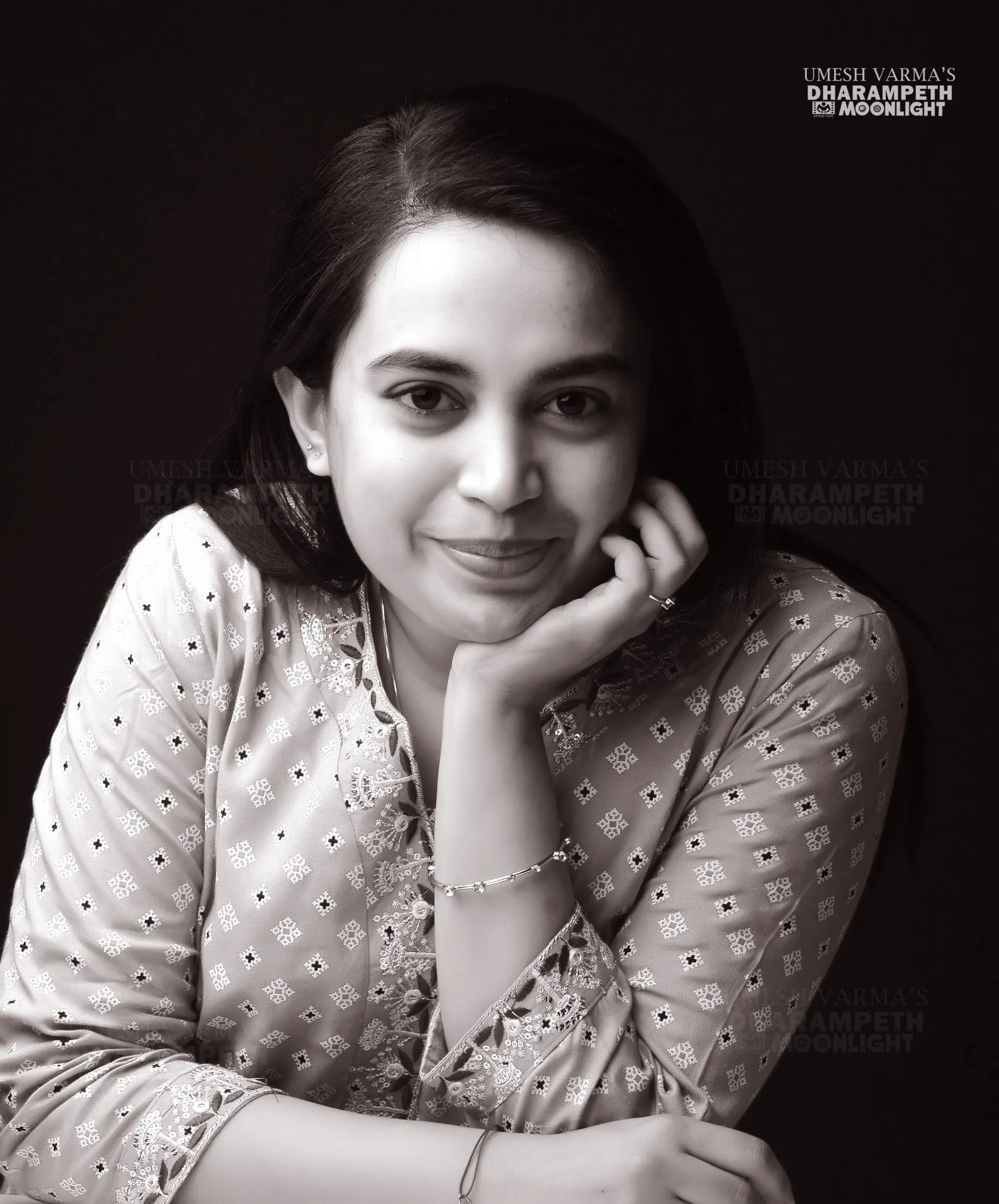 Black and white portrait of a woman resting her chin on her hand
